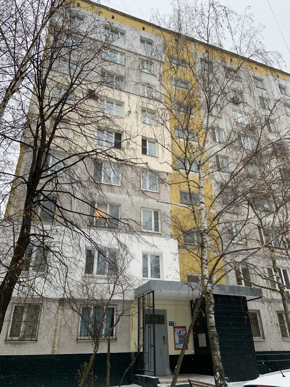 Фасад многоквартирного дома с участками наружных ремонтных работ